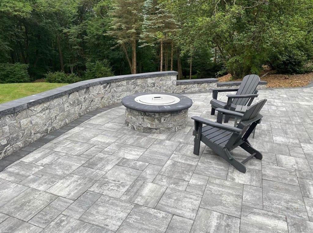 Paver patio with a fire pit and chairs