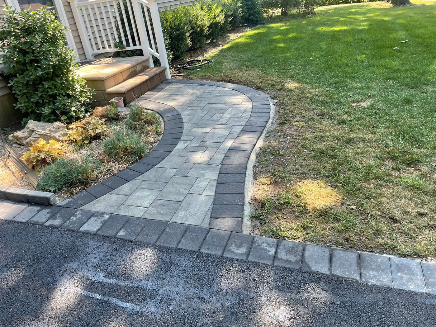 Paver walkway winding through a garden